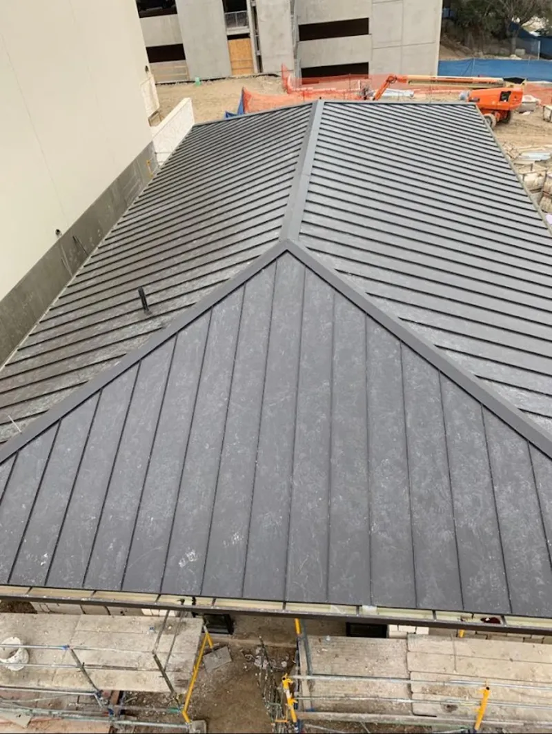 Commercial metal roof construction with crane equipment in Montevallo